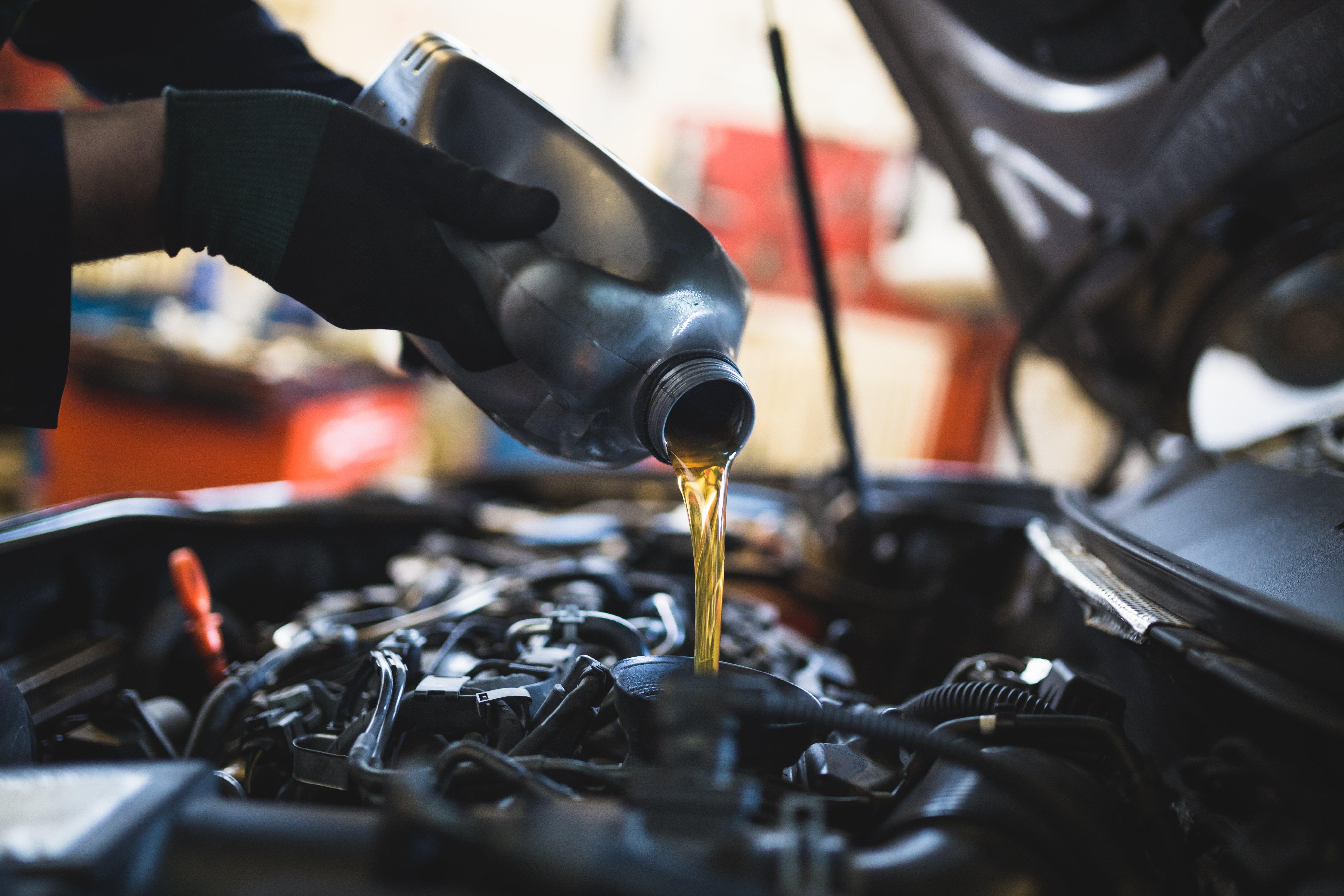 A dealership tech changing the oil in a car